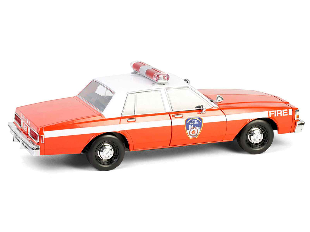 Red and white 1987 Chevrolet Caprice 9C1 FDNY diecast model car by Greenlight, part of the Artisan Collection, 1/18 scale.