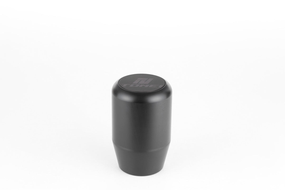 FR SPORT Tomei Duracon manual transmission shift knob with a sleek design, shown attached to a gear shifter in a car interior.