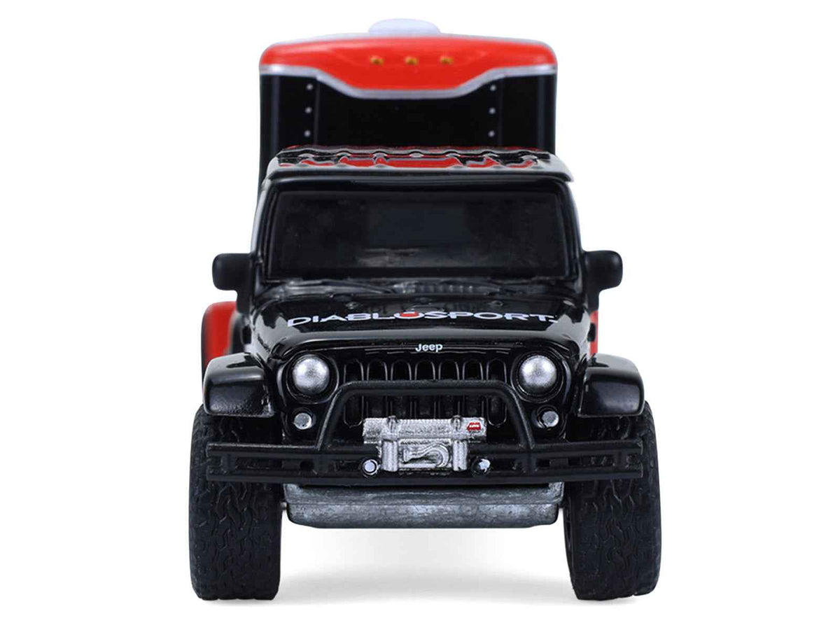 Miniature Motors 2012 Jeep Wrangler Unlimited Diablo Sport diecast model in black with red graphics, shown with small cargo trailer.