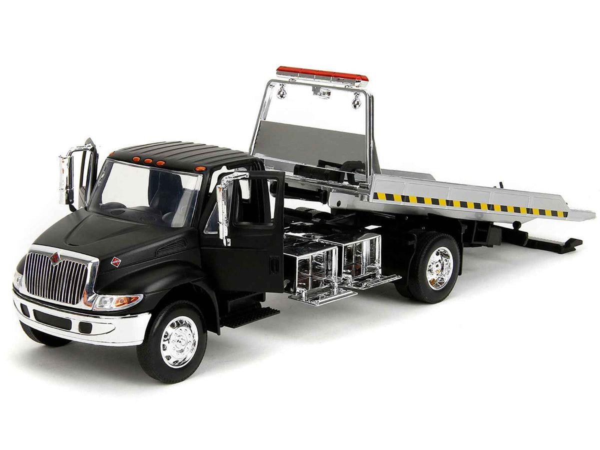 Miniature Motors International DuraStar 4400 flatbed tow truck diecast model in matte black, 1/24 scale by Jada.