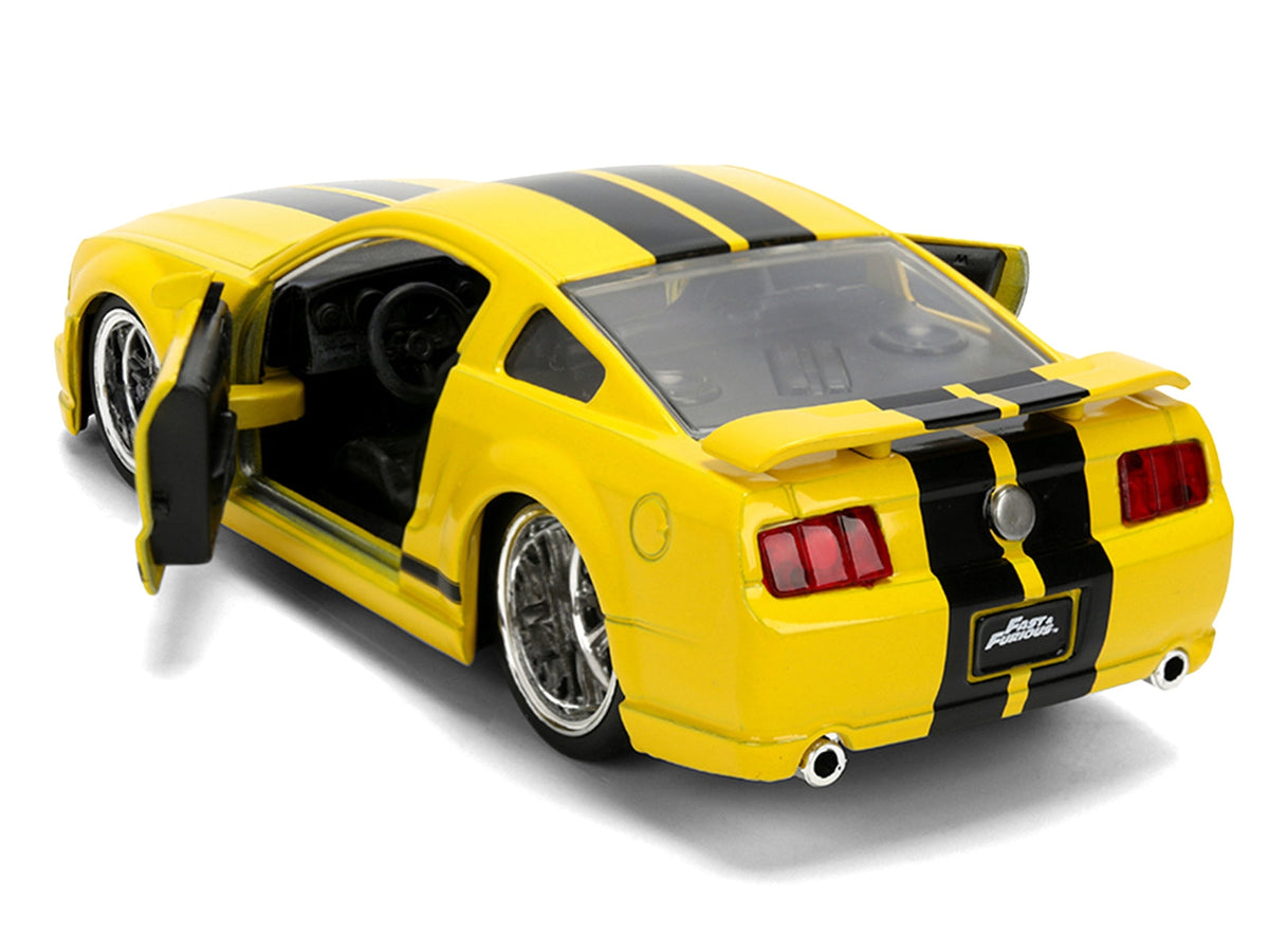 Yellow 2006 Ford Mustang GT diecast model car with black stripes from the Fast & Furious 25 Years series by Jada.