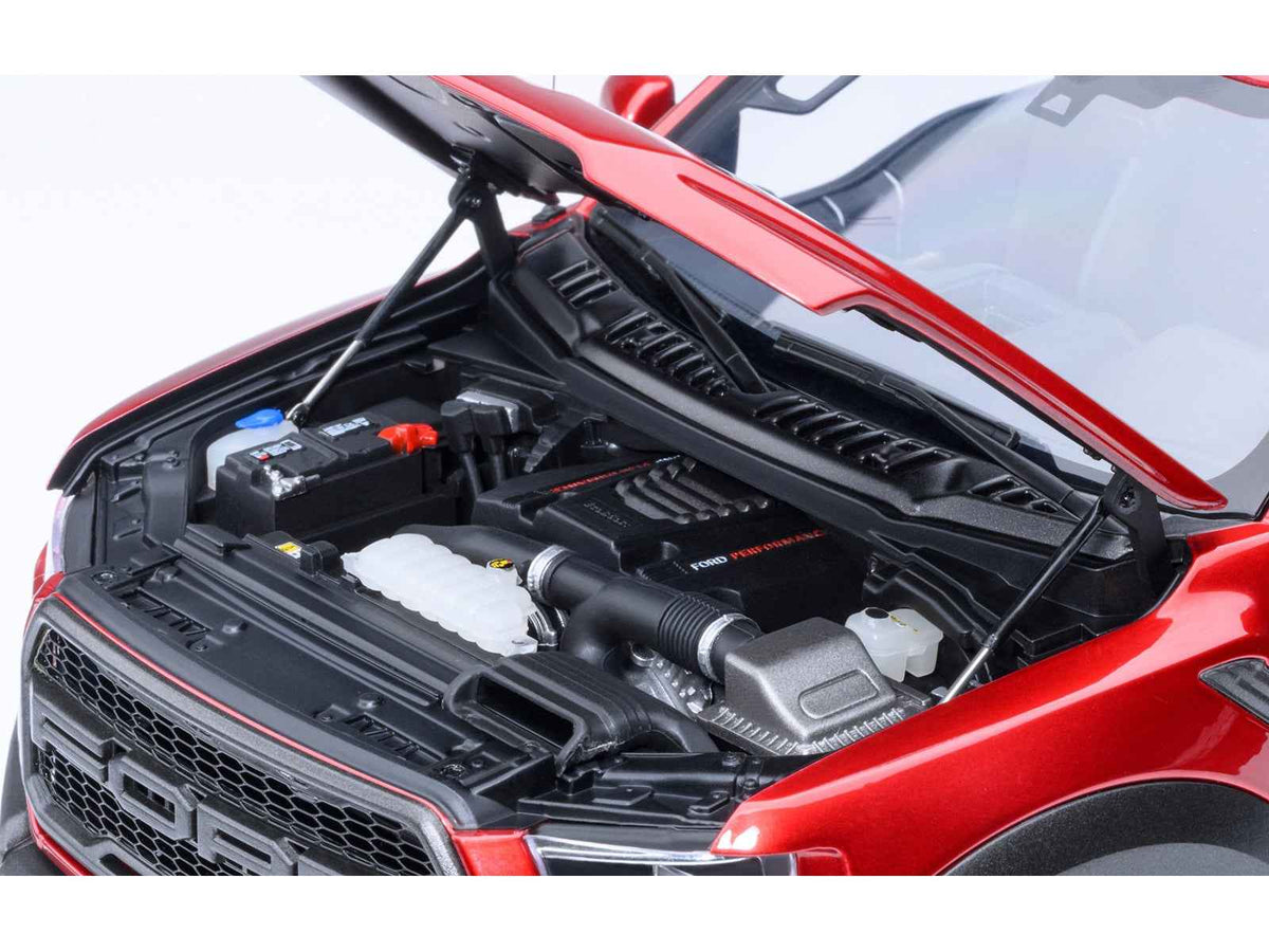 Miniature Ford F-150 Raptor 1/18 scale model car in Ruby Red Metallic by Autoart, detailed pickup truck toy.