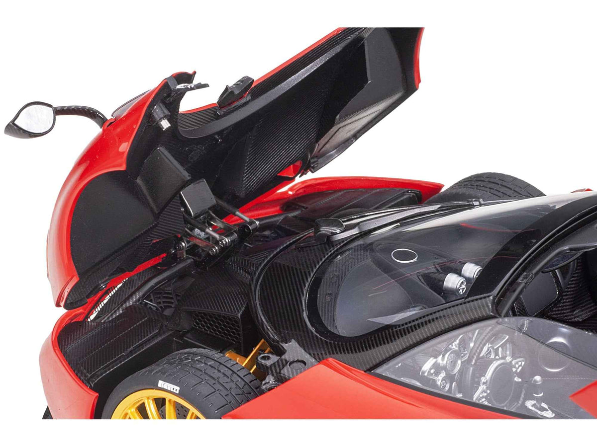 Miniature Pagani Huayra Roadster model car in Rosso Monza red with carbon details and luggage set, 1/18 scale by Autoart.