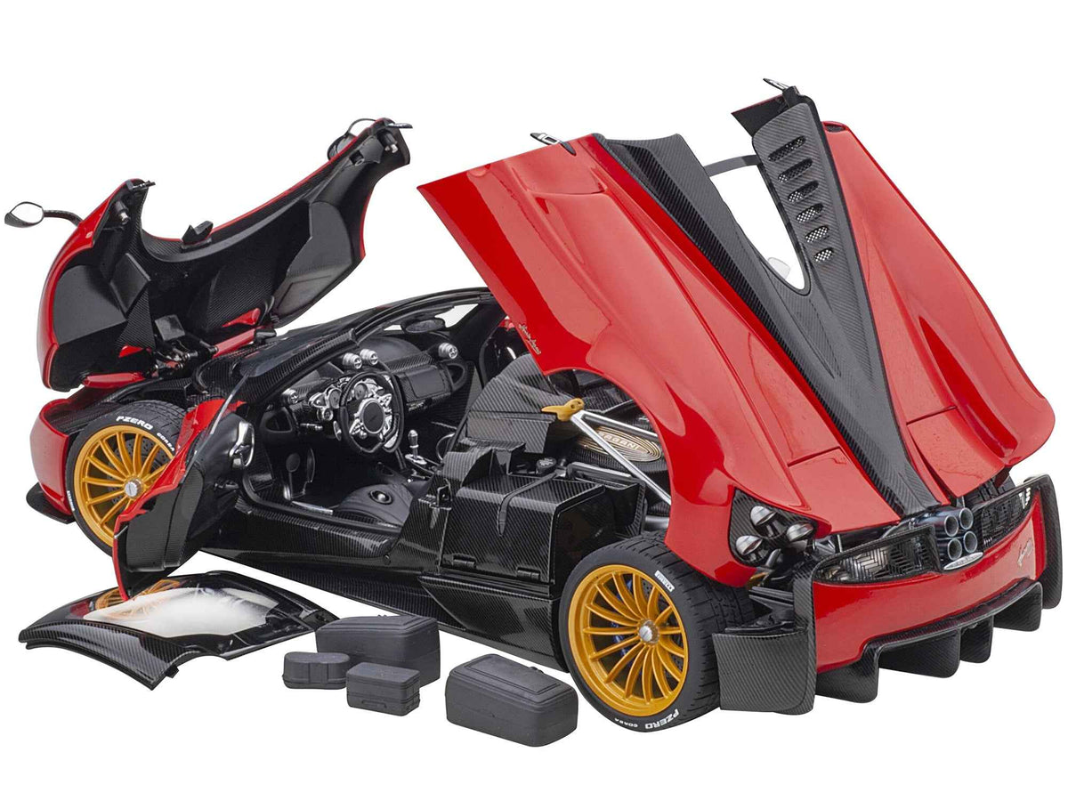 Miniature Pagani Huayra Roadster model car in Rosso Monza Red with carbon details and matching luggage set, 1/18 scale by Autoart.