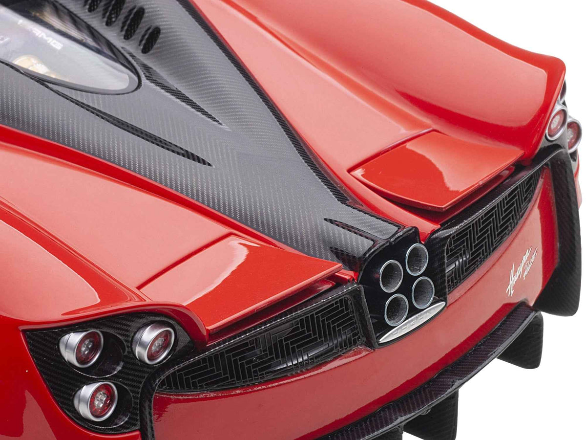 Miniature Pagani Huayra Roadster model car in Rosso Monza red with carbon details and luggage set, 1/18 scale by Autoart