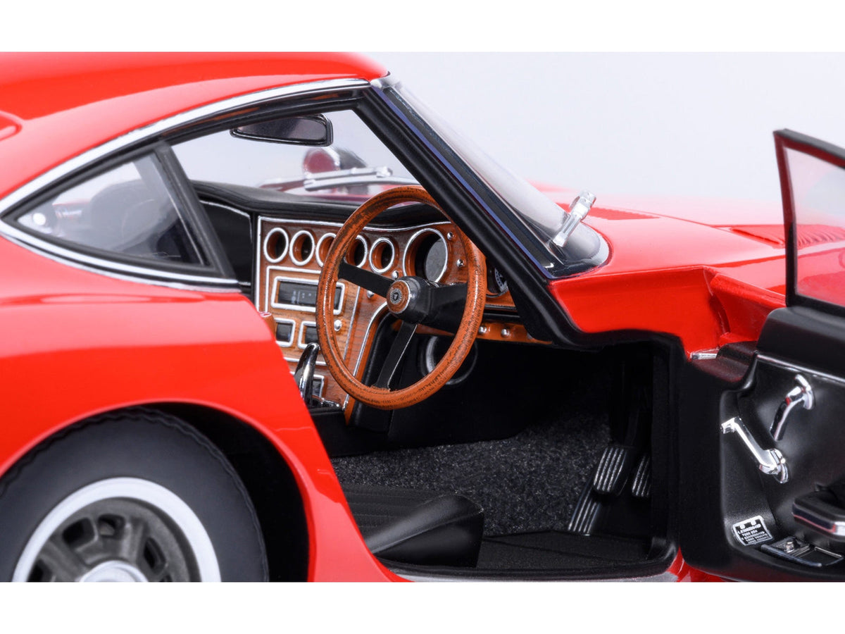 Red 1967 Toyota 2000GT RHD 1/18 scale model car by Autoart, featuring detailed miniature design and authentic Toyota branding.