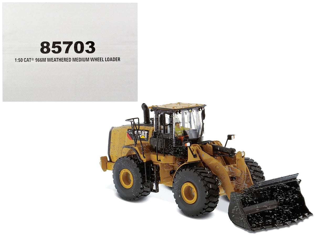 Weathered Cat Caterpillar 966M wheel loader diecast model by Diecast Masters, detailed construction scale model with operator figure.