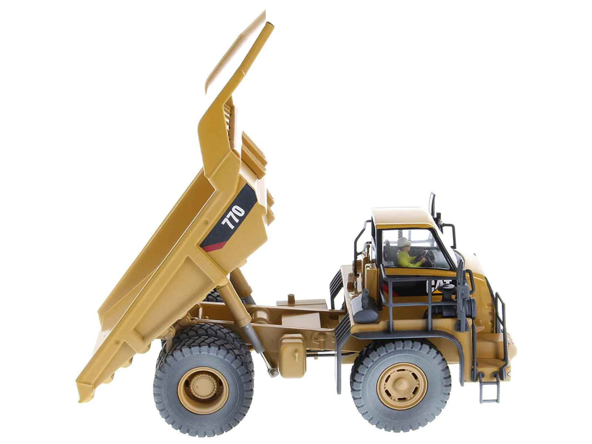 Weathered yellow CAT Caterpillar 770 off-highway truck diecast model by Diecast Masters, with operator figure, detailed construction replica.