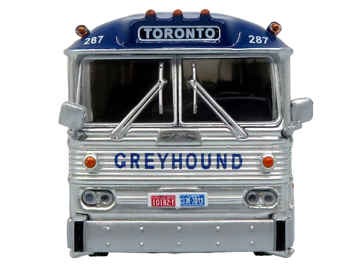 Miniature Motors 1964 MCI MC-5A Greyhound Canada coach bus diecast model in white with blue stripes, vintage bus collector's item.