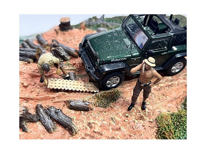 Two 1/43 scale diecast mechanic figures from Miniature Motors' 4X4 Mechanics set, dressed in work uniforms, with detailed tools.