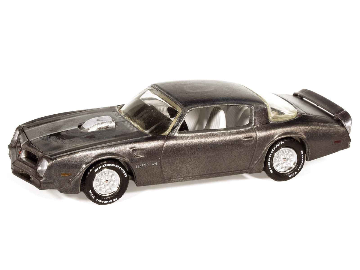 Weathered 1976 Pontiac Firebird T/A diecast model by Miniature Motors, gray metallic with white interior, part of Auto World 2025 series