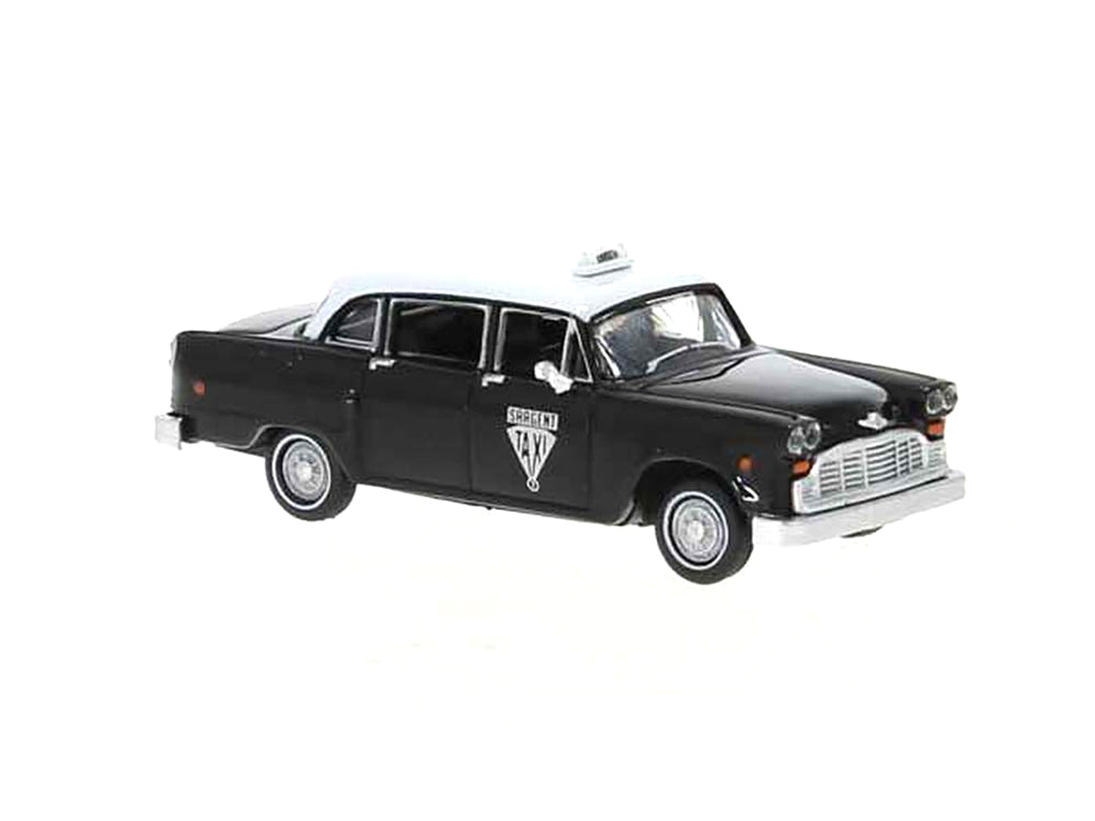 Black and white 1974 Checker Taxi model car by Brekina, HO scale 1/87, detailed miniature of Winnipeg cab by Miniature Motors.