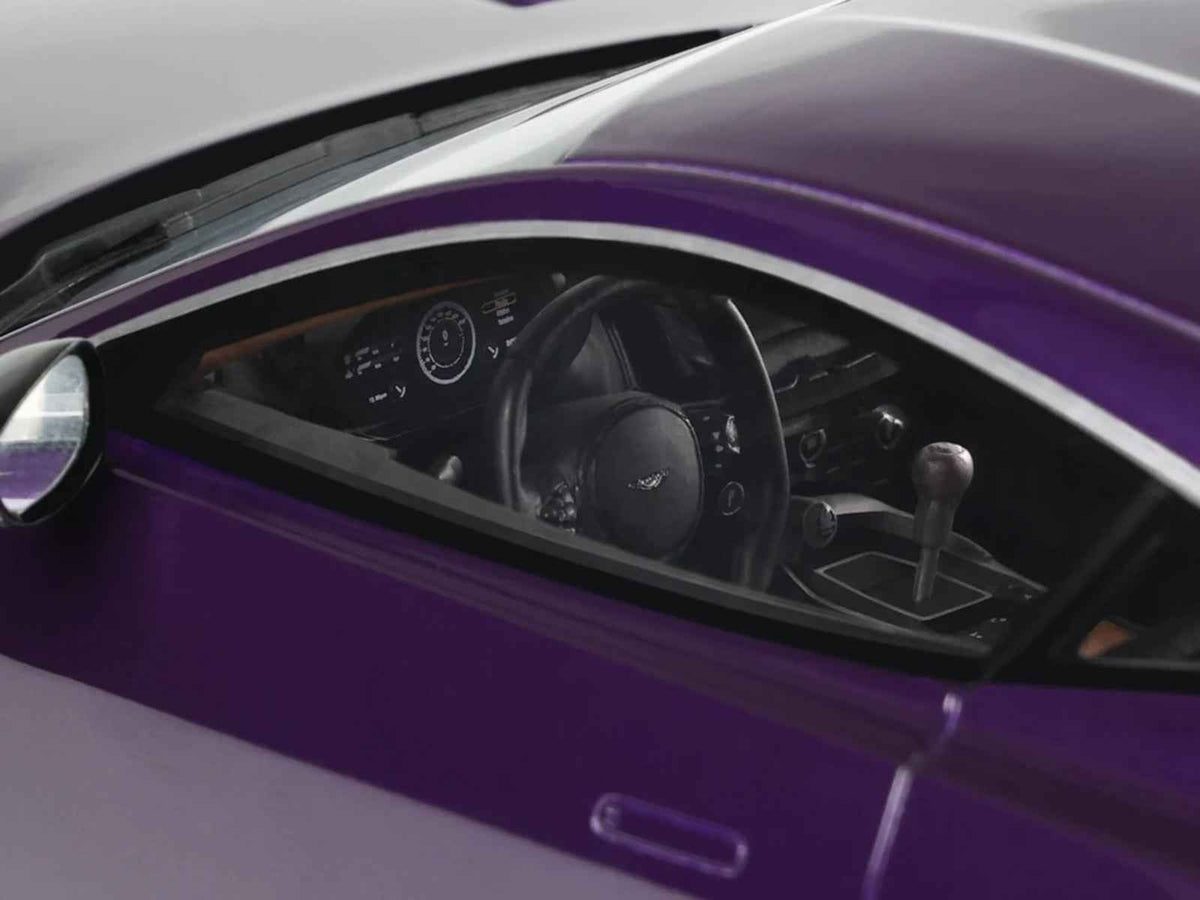 Miniature 1/18 Aston Martin Valour model car in purple metallic by GT Spirit, detailed replica showcasing sleek design and intricate features.