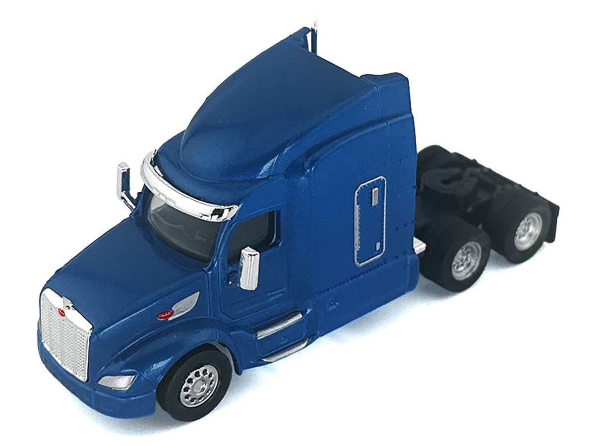 Blue metallic Peterbilt 579 sleeper cab plastic model car in 1/87 scale by Miniature Motors, detailed HO Logistics miniature.