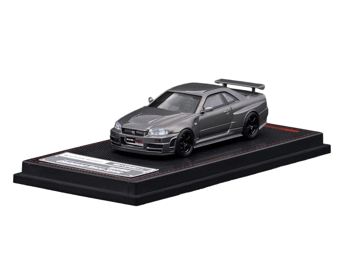 Gray metallic Nissan Skyline GT-R BNR34 Nismo CRS diecast model car in 1/64 scale by Miniature Motors, detailed right-hand drive display.