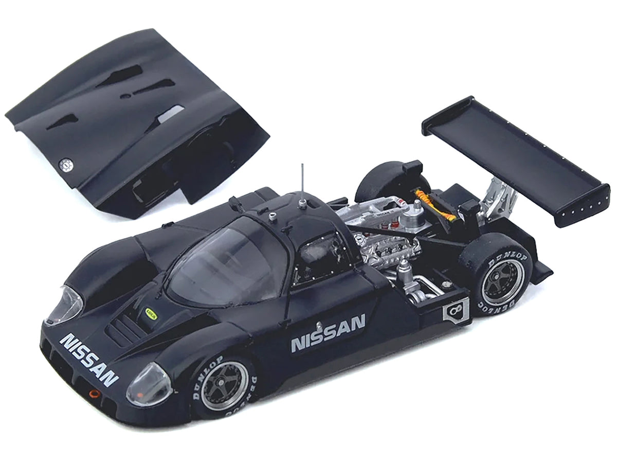 Nissan R89C Miniature Motors 1/64 diecast model car in matte black, showing detailed design from the Le Mans Shakedown Test at Paul Ricard 1988