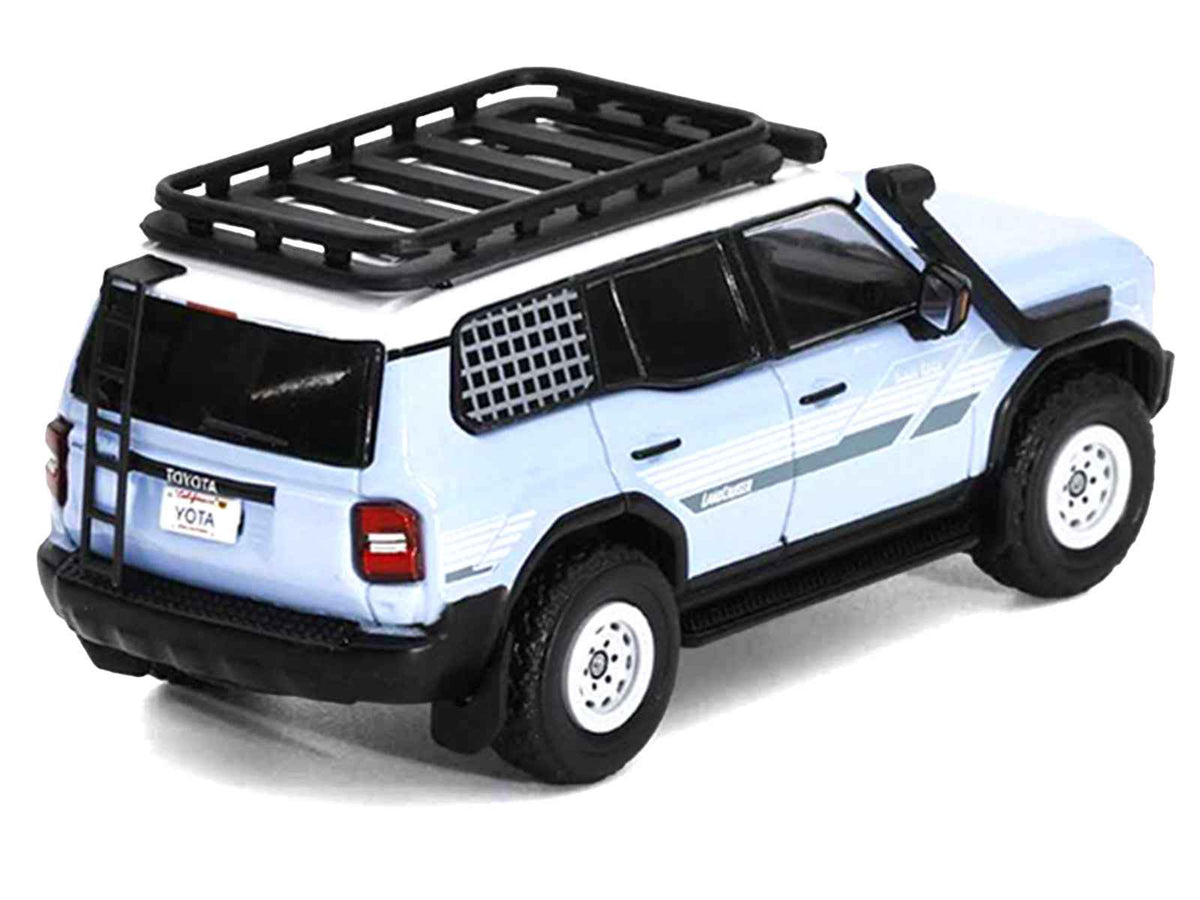 Miniature Motors 1/64 diecast model of a 2024 Toyota Land Cruiser Prado in light blue with white top, stripes, roof rack, and accessories.