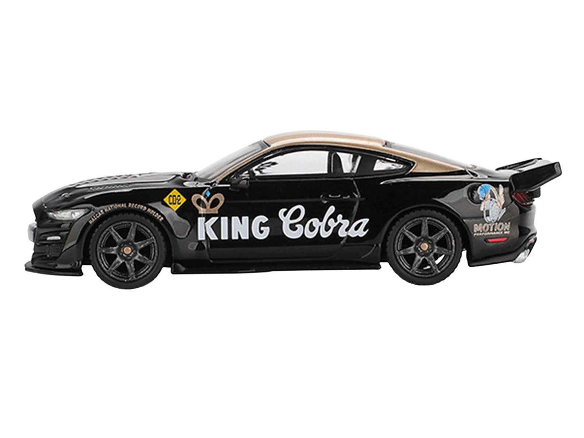 Mini GT Shelby GT500 Dragon Snake Concept "King Cobra" 1/64 diecast model car in black with gold metallic top, limited edition collectible.