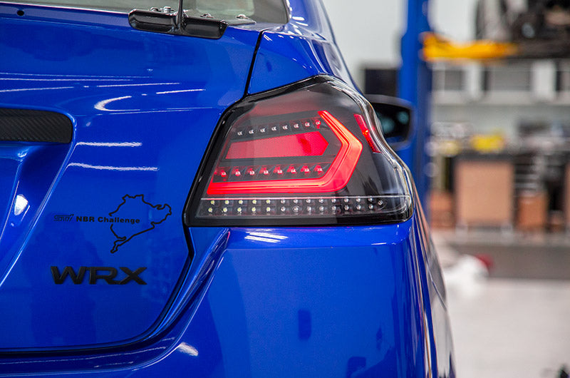 OLM Evolution tail lights with clear lens, black base, and white bar for 2015-2021 Subaru WRX and STI vehicles.