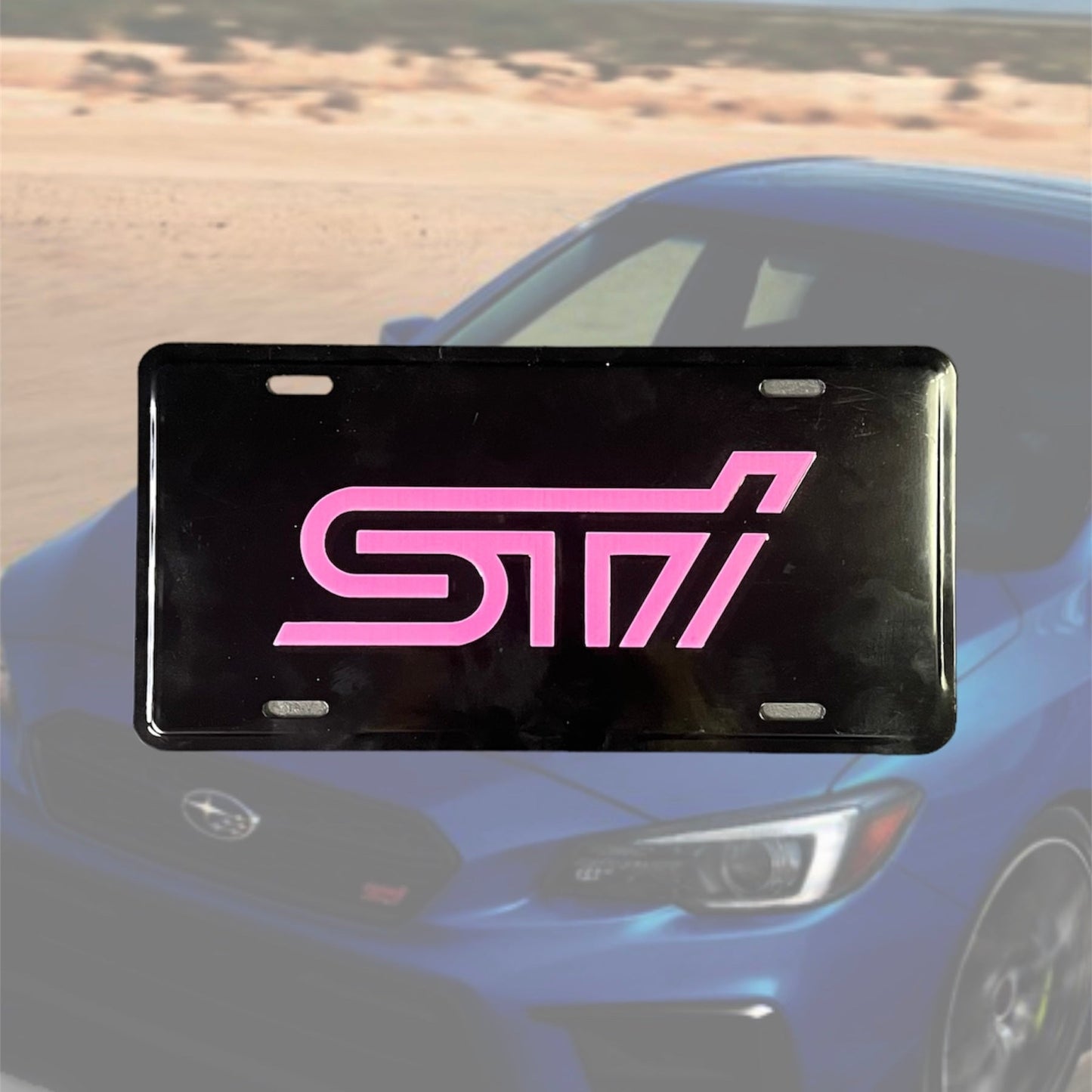 Illumaesthetic STI dealer license plate with bold branding, displayed on a vehicle in a clear outdoor setting.