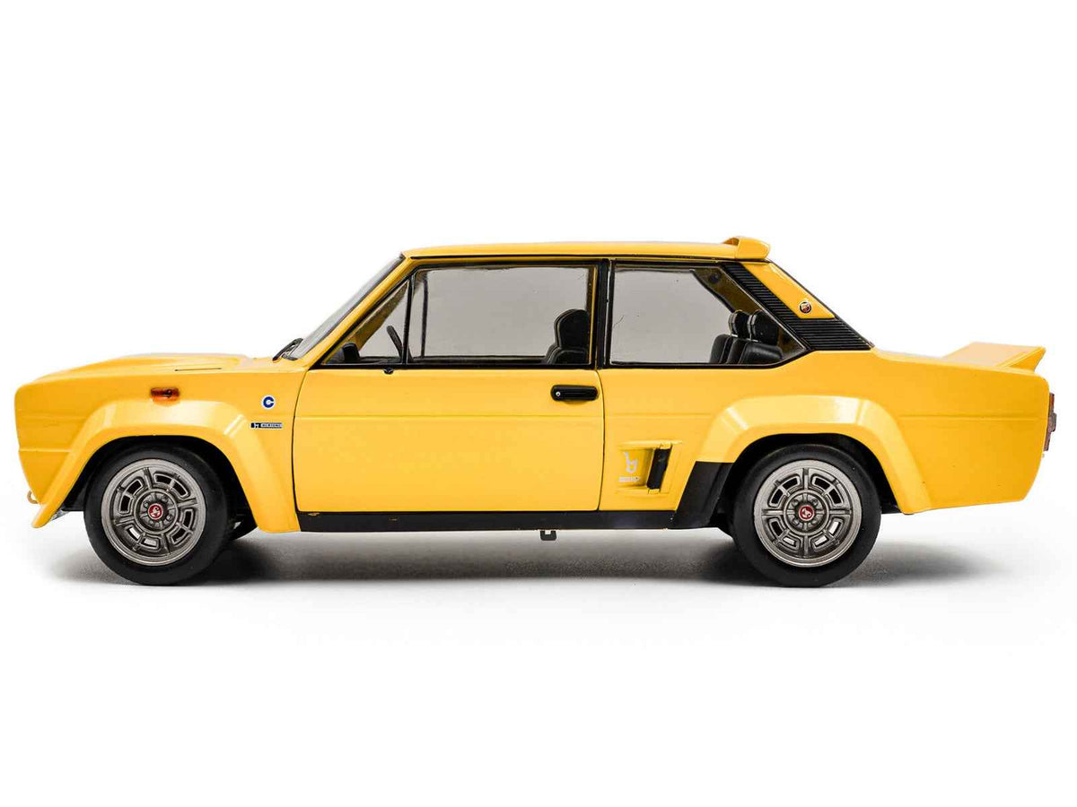 Yellow 1980 Fiat 131 Abarth 1/18 diecast model car by Solido, detailed miniature vehicle on display.