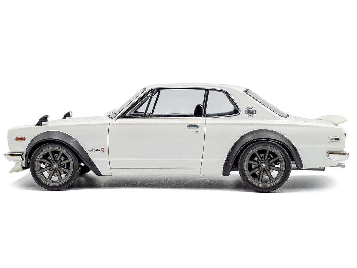 White 1/18 scale Nissan Skyline C10 Hakosuka diecast model car by Solido, right-hand drive, detailed miniature collectible.