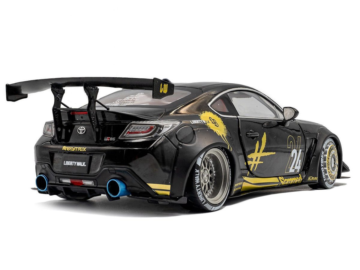 2024 Toyota GR86 Liberty Walk body kit diecast model car by Solido, black with gold graphics, right-hand drive, 1/18 scale.