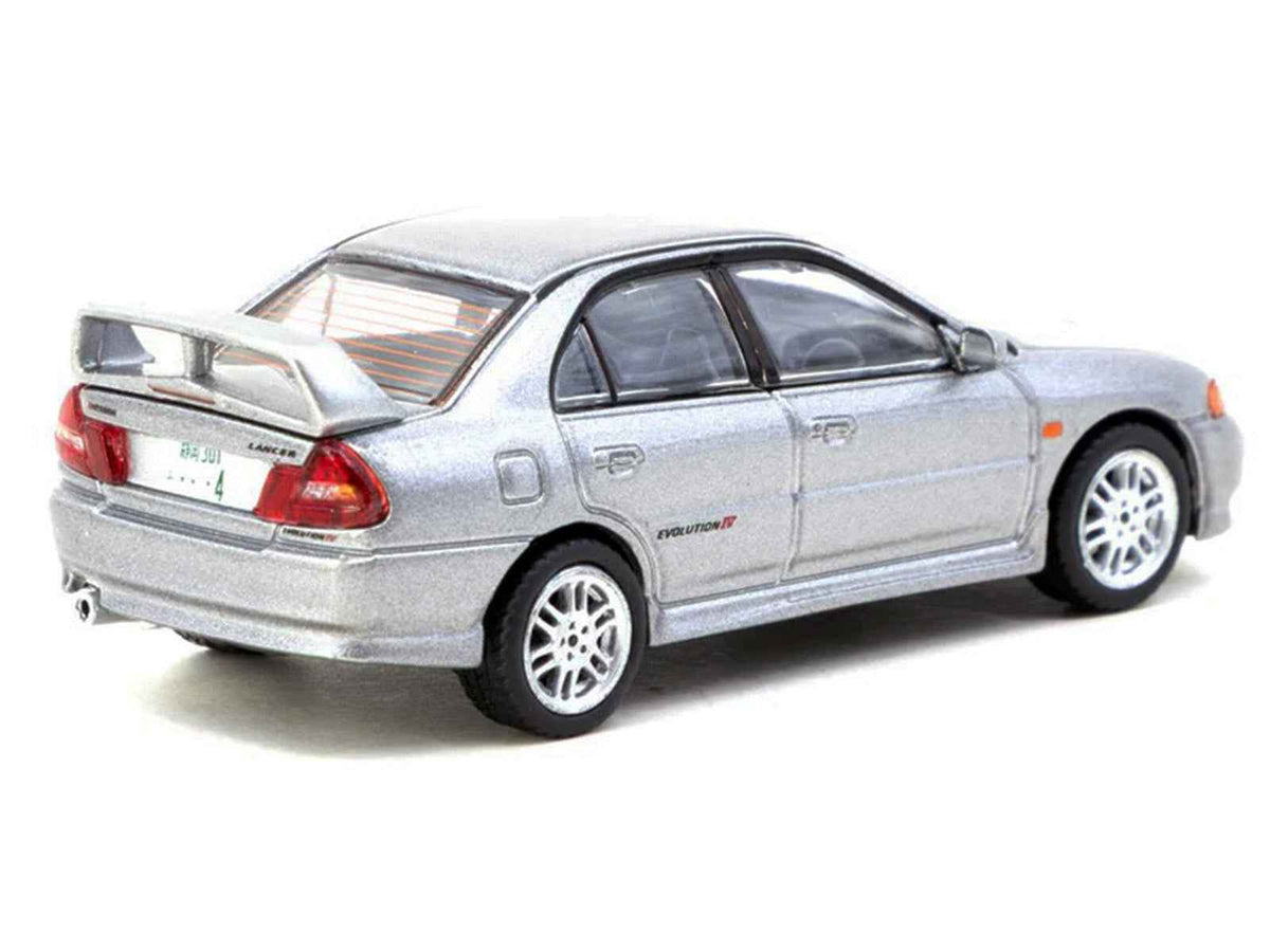 Silver metallic Mitsubishi Lancer Evolution IV diecast model by Tarmac Works, detailed miniature car with Tarmac cards, part of Global64 series.
