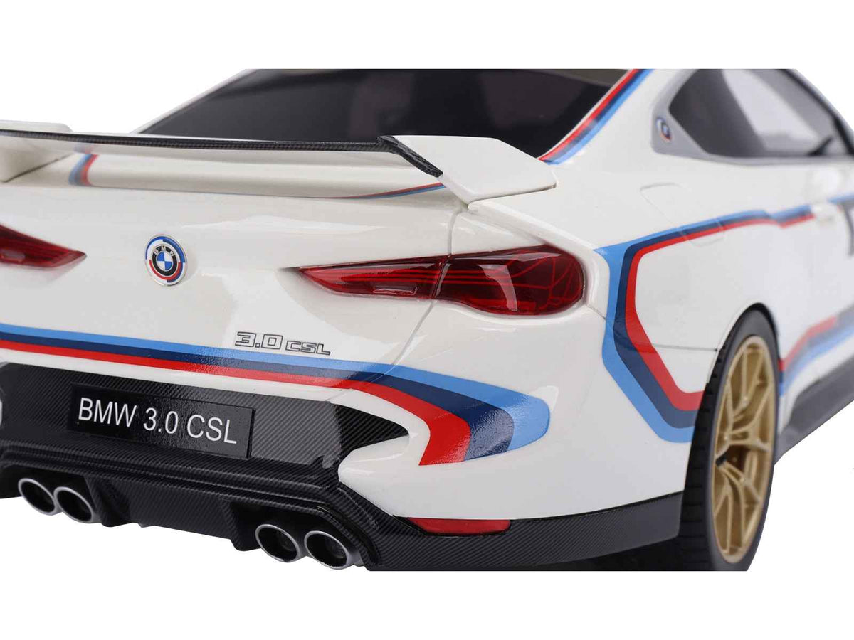 Miniature BMW M4 3.0 CSL model car in white with blue and red stripes, detailed 1/18 scale replica by Miniature Motors.