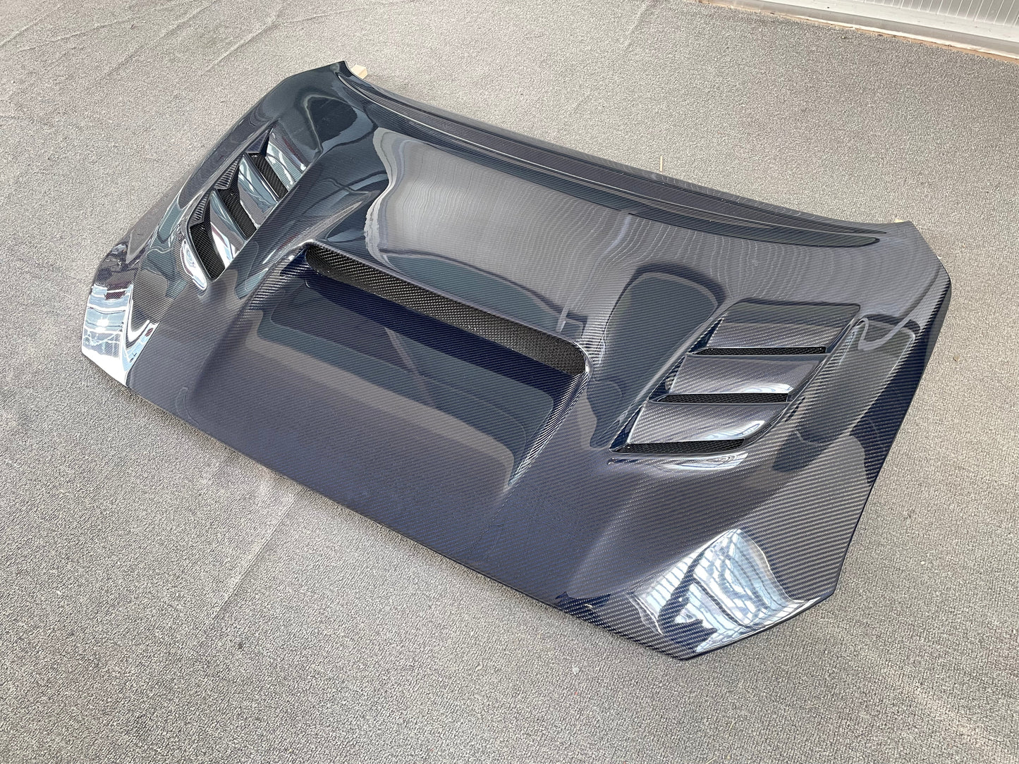 JDMuscle carbon fiber hood V2 with heat extract vents on a 2015-2021 Subaru WRX/STI, showcasing lightweight, aerodynamic design.