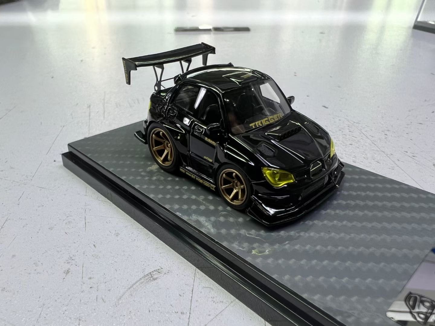 Miniature black and gold Subaru Impreza WRX STI diecast model by YM Model, detailed 1:64 scale, showcasing sporty design.
