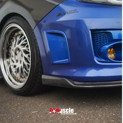 JDMuscle front carbon fiber lip for 2011-2014 Subaru WRX/STI, stylish aerodynamic car bumper lip with a sleek carbon fiber finish.
