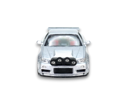 Silver Nissan R34 GT-R diecast model from Lot57Supplies, detailed 1:64 scale street weapon with snow drift design.