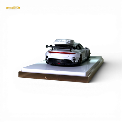 White Porsche Taycan diecast model with roof box, 1:64 scale, detailed miniature car in a realistic pose.