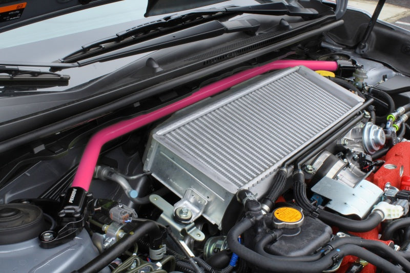 JDMuscle Perrin Hyper Pink front strut tower bar for 2008-2021 Subaru WRX and STI, installed on vehicle engine bay.