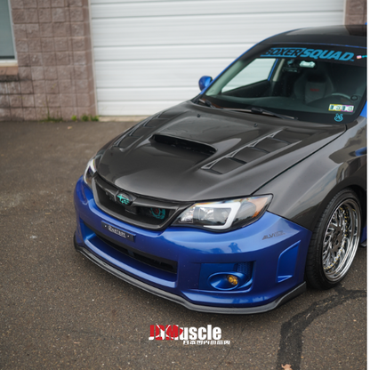 JDMuscle front carbon fiber lip for 2011-2014 Subaru WRX/STI, sleek vehicle front lip enhancement with textured carbon fiber finish.