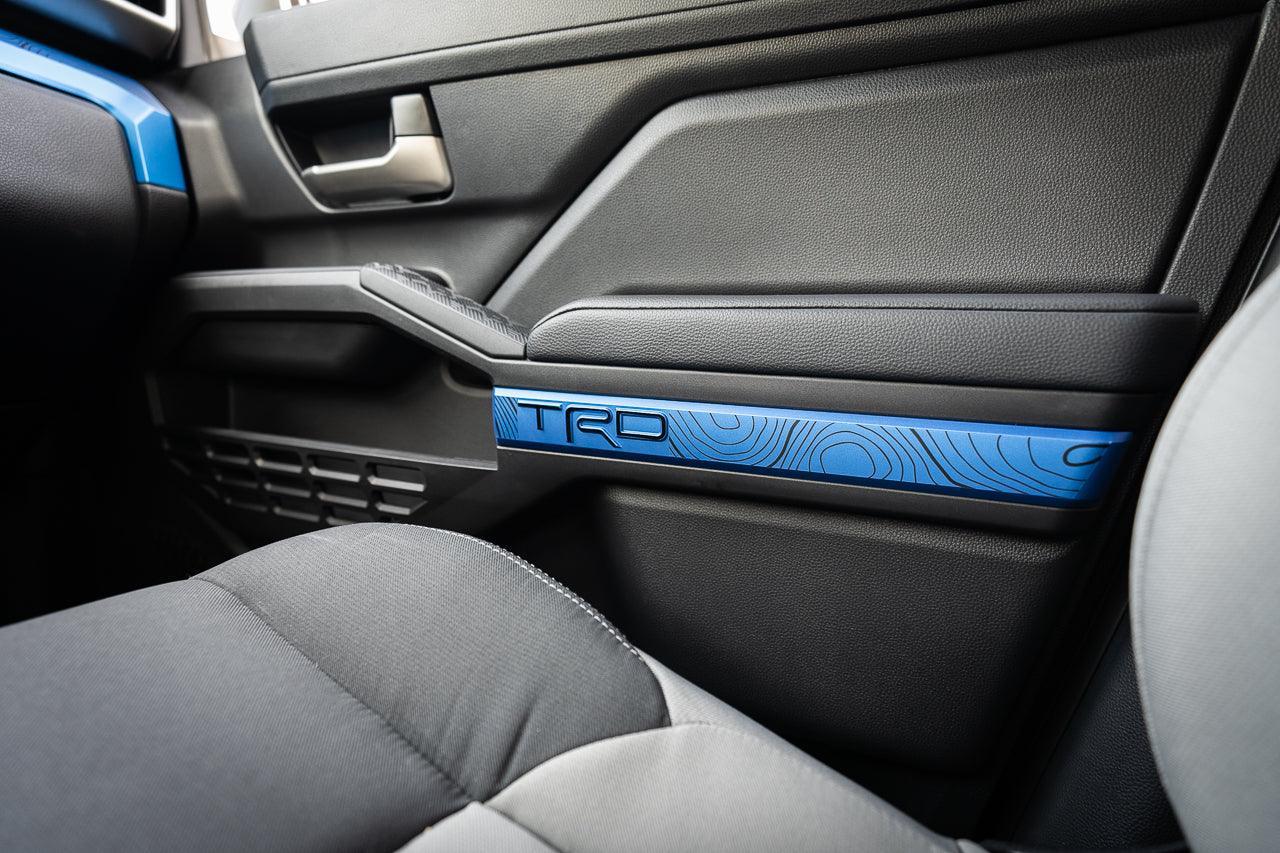 Black vinyl TRD door line overlays for 2024+ Toyota Tacoma interior, shown on a vehicle's door panel.