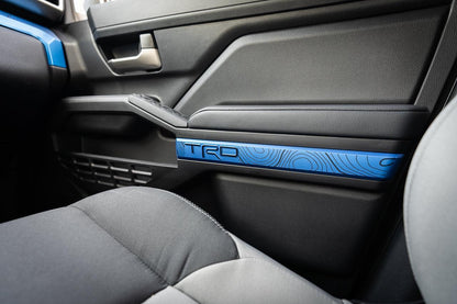 Black vinyl TRD door line overlays for 2024+ Toyota Tacoma interior, shown on a vehicle's door panel.