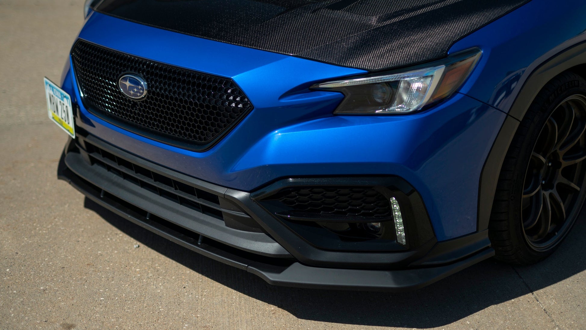 OLM RD1 Style 3-piece matte black ABS front lip for 2022+ Subaru WRX, showing the sleek aerodynamic design on the car's front bumper.