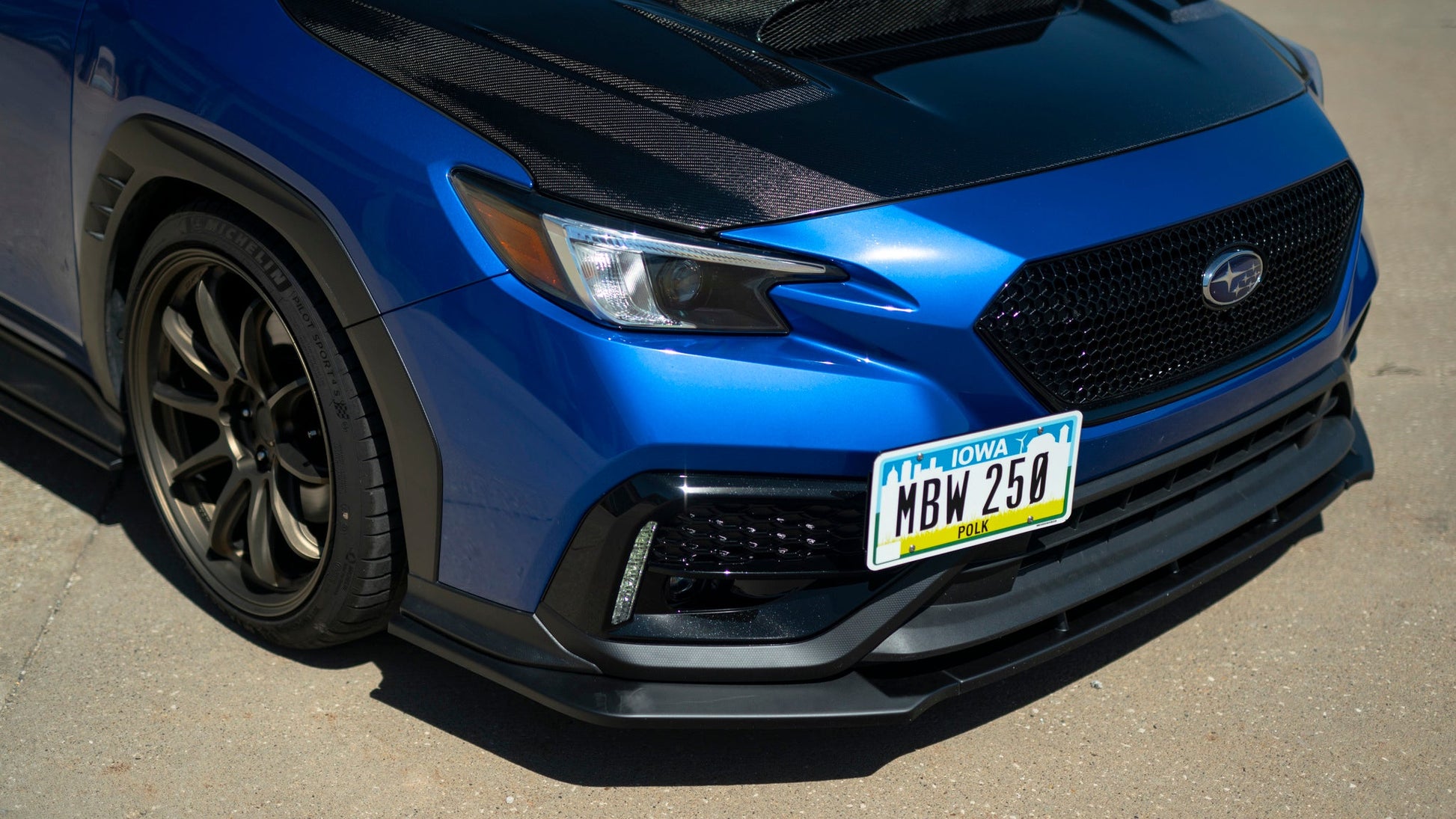 OLM RD1 Style matte black ABS front lip for 2022+ Subaru WRX, enhancing aerodynamics and sporty appearance.