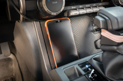 StickerFab 25W Magsafe wireless charger pad mounted in factory cubby for 2024+ Tacoma and 2025+ 4Runner vehicles.