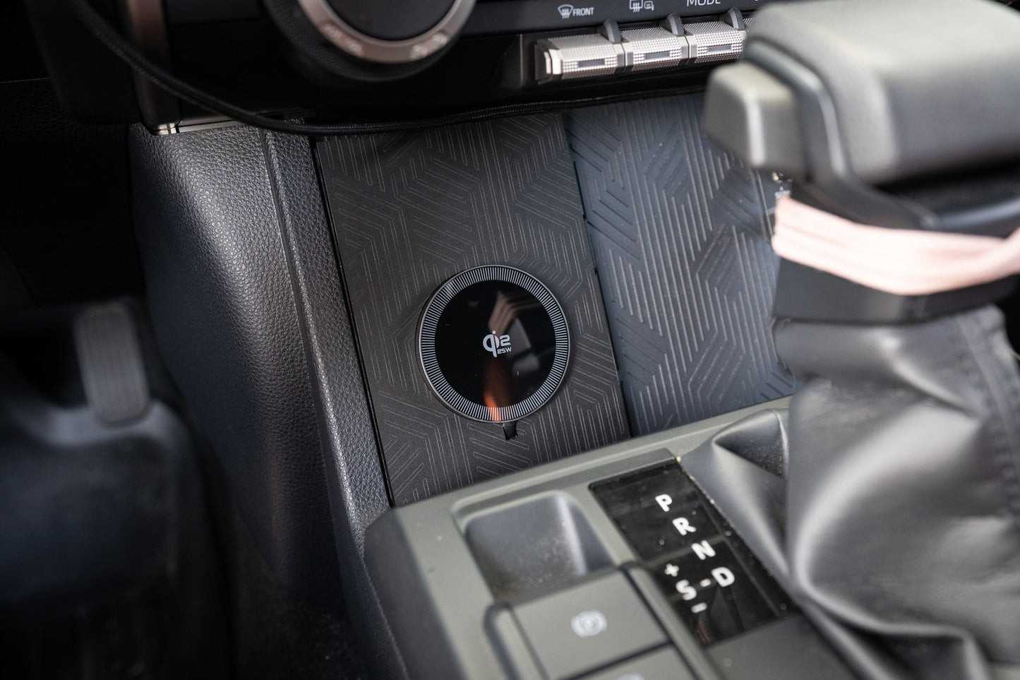 StickerFab 25W MagSafe wireless charger pad mounted in factory cubby for 2024+ Tacoma and 2025+ 4Runner vehicles.