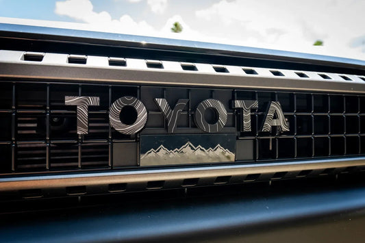 Toyota Topo front grille emblem kit for 2024+ Land Cruiser and 07-14 FJ Cruiser, includes durable emblems for vehicle branding.
