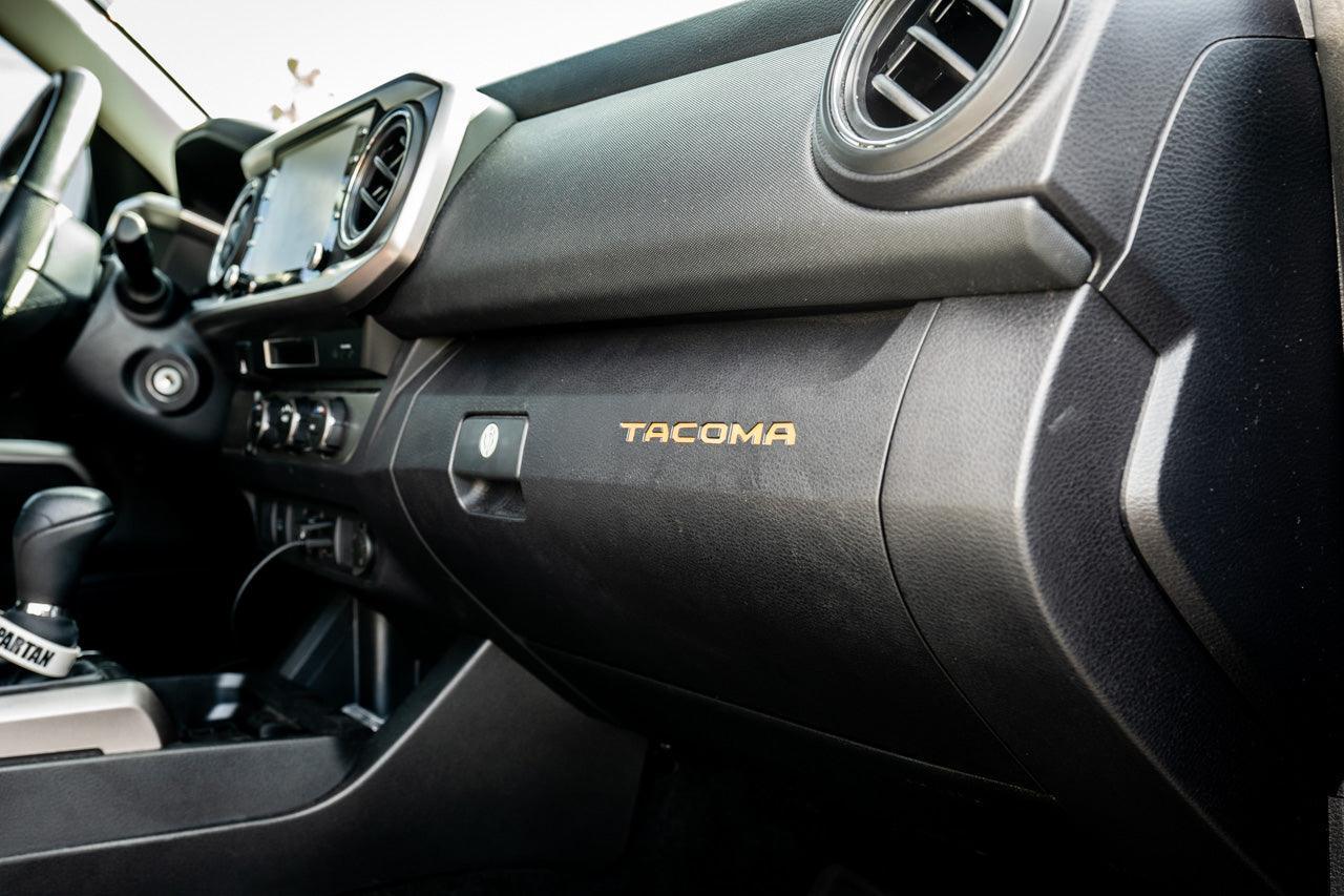 Vinyl glove box inlay with Tacoma logo for 2016-2023 Toyota Tacoma interior, standard series by StickerFab.
