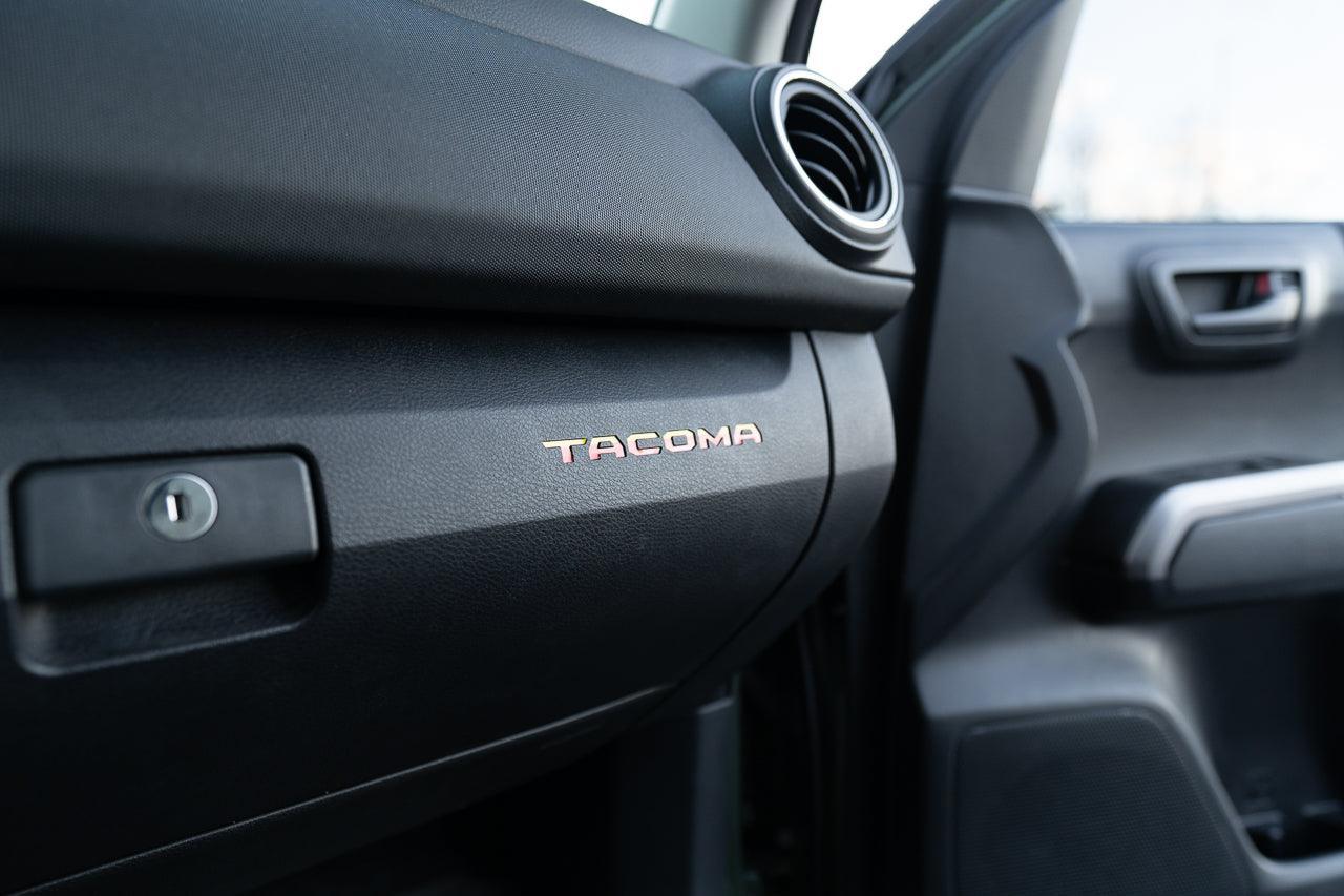 Tacoma glove box interior with StickerFab printed vinyl logo inlays for 2016-2023 Tacoma trucks.