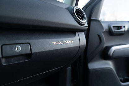 Tacoma glove box interior with StickerFab printed vinyl logo inlays for 2016-2023 Tacoma trucks.
