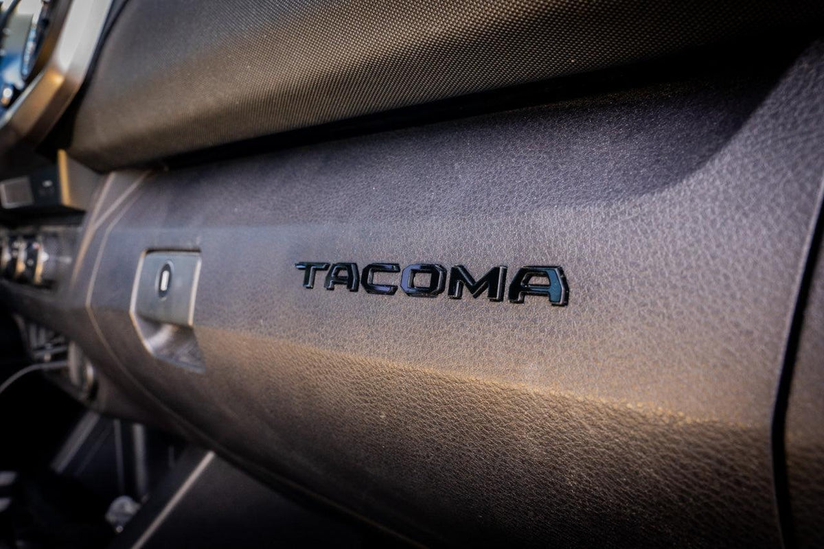 Tacoma glove box with acrylic "TACOMA" logo inlays from StickerFab's Laser Series interior vinyl decal, 2016-2023 model.