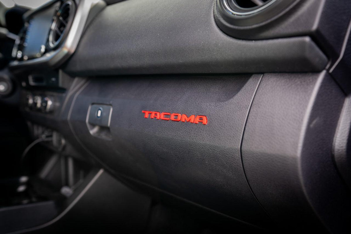 Tacoma glove box with acrylic "TACOMA" logo inlays from StickerFab's Laser Series, vinyl interior for 2016-2023 Tacoma trucks.
