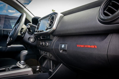 Tacoma glove box with StickerFab acrylic logo inlays from the Laser Series, featuring custom vinyl interior accents for 2016-2023 models.