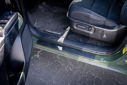 StickerFab Topo Door Sill Protectors for 2016-2023 Toyota Tacoma Double Cab, close-up of textured black and gray door sill guards.